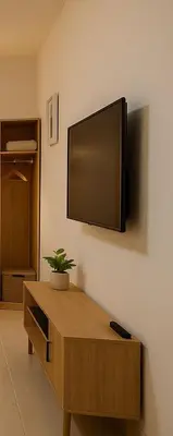 a flat screen tv hanging on a wall at Stay with Obada Private Room in Amman