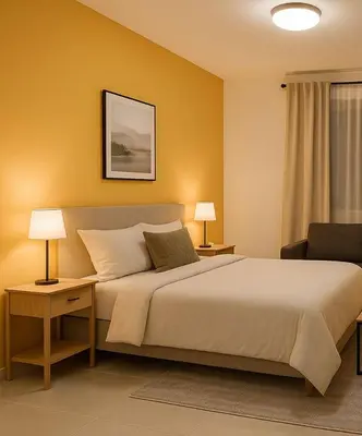 a bedroom with a bed with two lamps and a chair at Stay with Obada Private Room in Amman