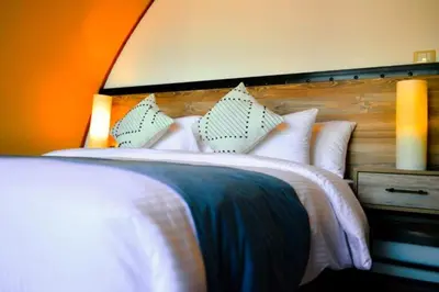 a bedroom with a bed with white pillows at Luxury Spiral Camp in Maḩaţţat Dīsah