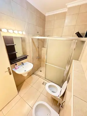 a bathroom with a toilet and a sink at Abdoun Modern 2BR Apartment Near US Embassy in Amman