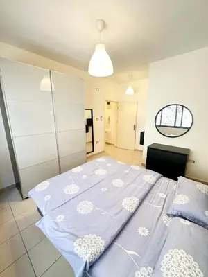 a bedroom with a large bed with blue sheets at Abdoun Modern 2BR Apartment Near US Embassy in Amman