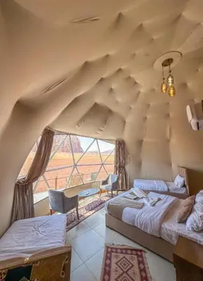 a room with two beds and a large window at RUM iSLAND bubble LUXURU CAMP in Wadi Rum