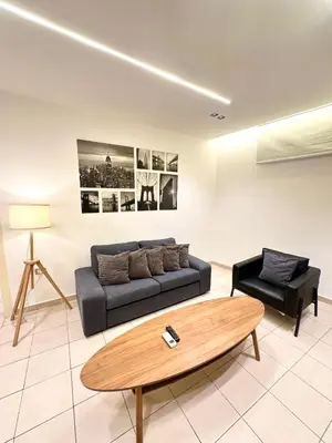 a living room with a couch and a coffee table at Abdoun Modern Apartment Near US Embassy in Amman