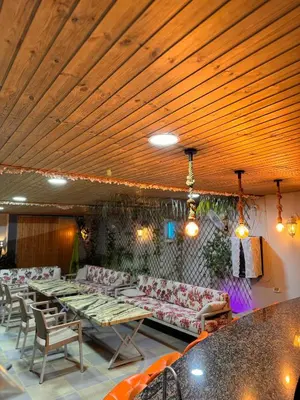 a room with couches and tables in a restaurant at Private villa with pool in Deadsea Jordan in Al Rama