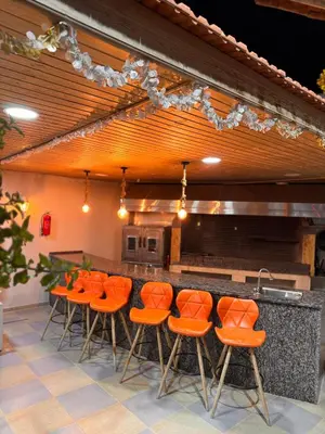 a bar with orange chairs and a counter at Private villa with pool in Deadsea Jordan in Al Rama