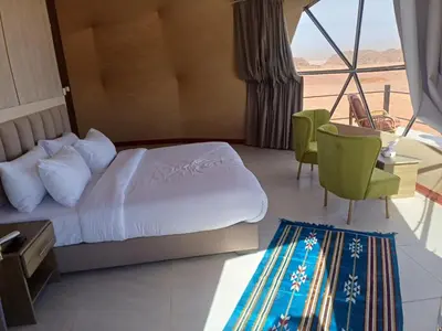 a hotel room with a bed and a view of the desert at ATAYA sunrise camp in Disah
