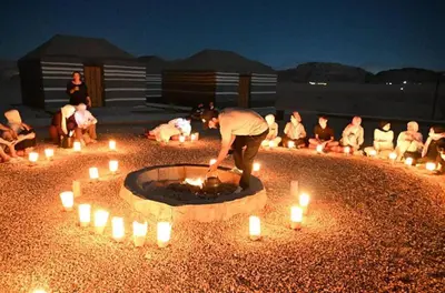 a group of people sitting around a circle with candles at ATAYA sunrise camp in Disah