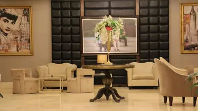 a cat laying on the floor in a room with a table at Sandy Palace Hotel Amman in Amman