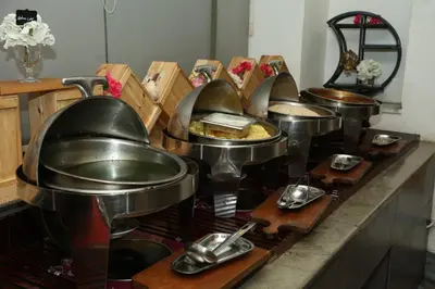 a row of pans on a counter in a kitchen at Sandy Palace Hotel Amman in Amman