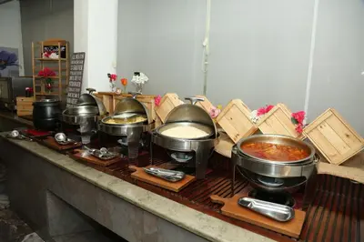 a group of pots and pans on a counter with food at Sandy Palace Hotel Amman in Amman