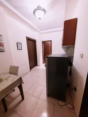 a kitchen with a counter and a table in a room at شقة في ضاحية الرشيد in Amman