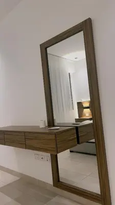 a mirror on a wall next to a dressing table at شقه بغرفة نوم في قريه الراحة one bedroom apartment in alraha village in Al Jafr