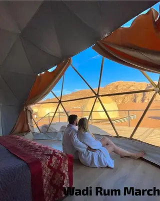 a man and woman sitting inside of a tent at Wadi Rum March in Wadi Rum