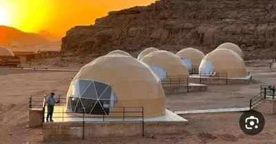 a group of domes in a desert with a man standing in front at Wadi Rum March in Wadi Rum