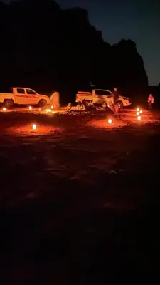 two trucks parked in a parking lot at night at Desert Horizon Camp in Disah