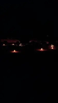 a group of cars driving at night with lights at Desert Horizon Camp in Disah