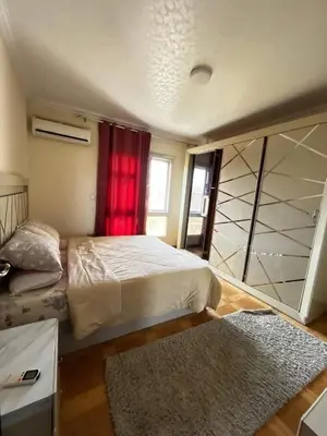a bedroom with a large bed and a red curtain at Jordan farm in Amman