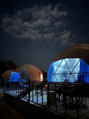 a group of domes with tables and chairs at night at Wadi rum sami camp in Wadi Rum