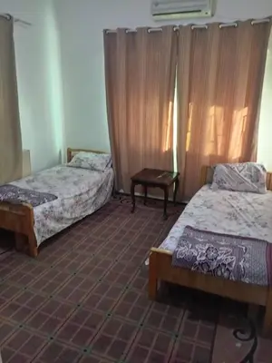 a room with two beds and a table in it at Al Martini Building Number 11 in Amman
