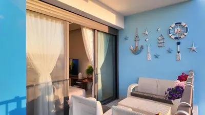 a living room with blue walls and white chairs at شقه للإيجار في ايله للعائلات in Aqaba
