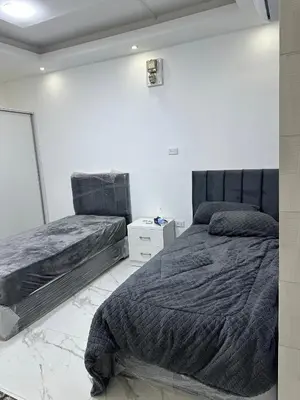 a bedroom with two beds and a white wall at Omar rent apartments in Amman