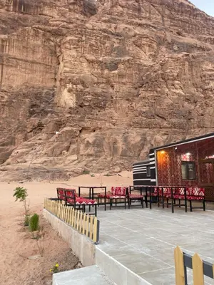 a building with tables and chairs in front of a mountain at Spirit of the Badia camp in Disah