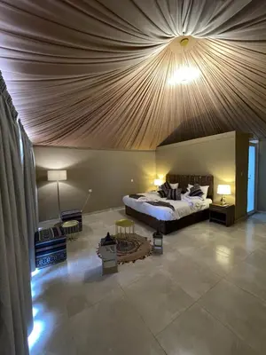 a bedroom with a large bed with a wooden ceiling at Spirit of the Badia camp in Disah