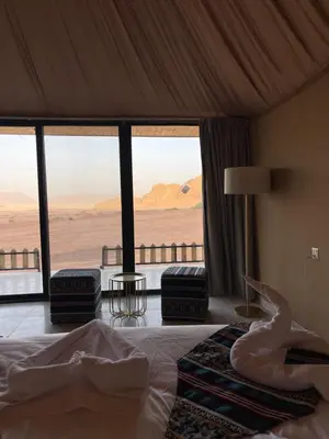 a bedroom with a bed with a view of the desert at Spirit of the Badia camp in Disah