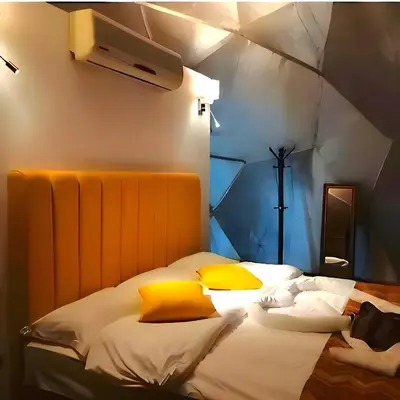 a bedroom with a large bed with yellow pillows at millennium camp in Wadi Rum