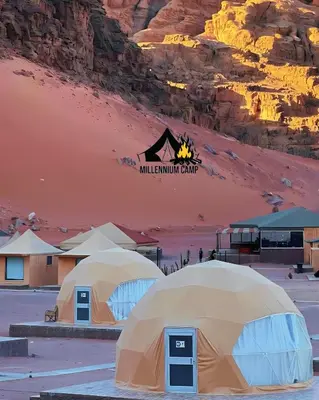 two tents in the desert with a mountain in the background at millennium camp in Wadi Rum