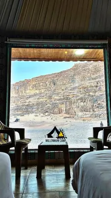 a bedroom with a view of the desert from a window at millennium camp in Wadi Rum