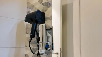 a hair dryer hanging from a door handle at واحة ايلة ازور in Aqaba
