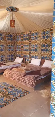 a bedroom with a bed in a tent at Wadi Rum Aura Camp in Wadi Rum