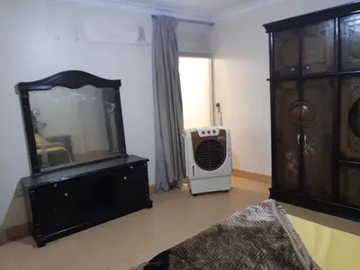 a living room with a fan and a dresser at Amman house in Amman