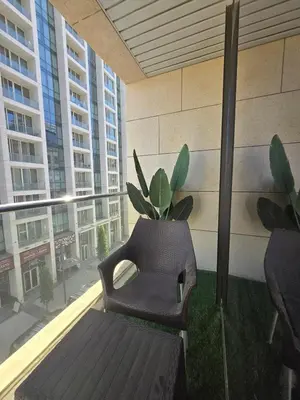 a bench sitting on a balcony with a plant at Pasha House - DAMAC Tower in Amman