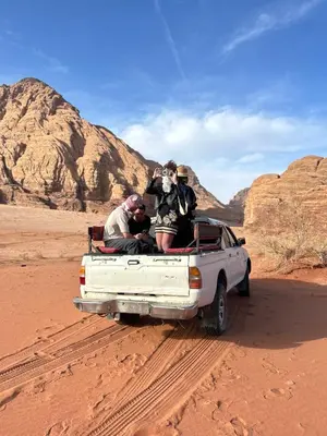 a group of people in the back of a truck in the desert at Bedouin Luxe Camp & Tour in Wadi Rum