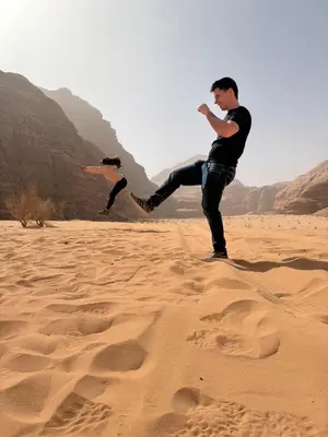 two men playing with a frisbee in the sand at Bedouin Luxe Camp & Tour in Wadi Rum