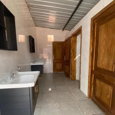 a large bathroom with a sink and a door at Sunrise Magic Camp in Wadi Rum