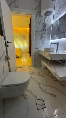 a white bathroom with a toilet and a sink at Luxury 3 Bedroom Family Apartment in Amman in Amman