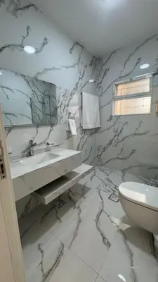 a marble bathroom with a sink and a toilet at Luxury 3 Bedroom Family Apartment in Amman in Amman