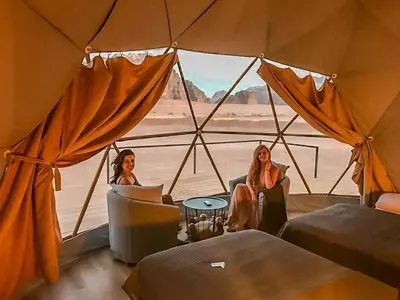 two women sitting in a tent looking out at the desert at TALA lUXURY CAMP in Wadi Rum