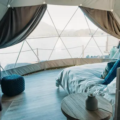 a bedroom in a tent with a bed and a table at Rum marea in Disah
