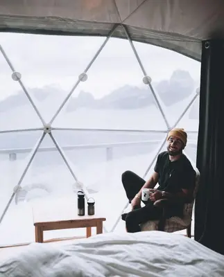 a man sitting in a chair in front of a window at Rum marea in Disah
