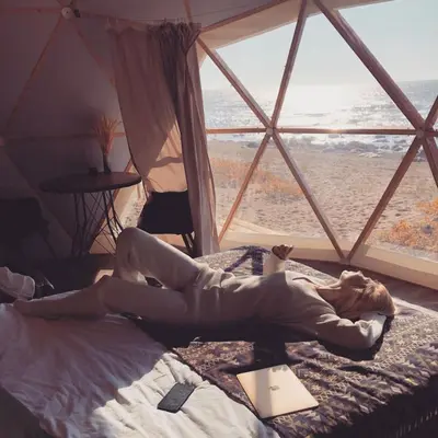 a woman laying on a bed in a room with a window at Rum marea in Disah