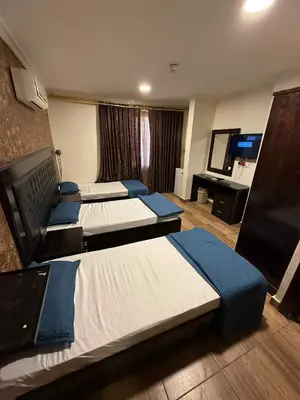 a hotel room with four beds and a flat screen tv at فندق برستيج العقبه Prestig in Aqaba