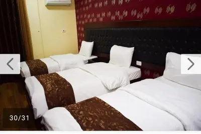 a group of three beds in a hotel room at فندق برستيج العقبه Prestig in Aqaba