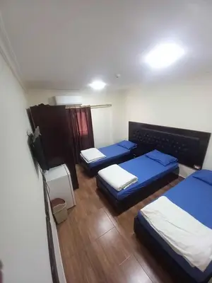 a room with three blue beds in it at فندق برستيج العقبه Prestig in Aqaba