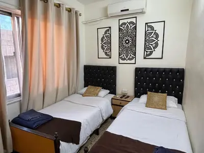 a room with two beds and a window at New Hamoudeh Hotel in Amman
