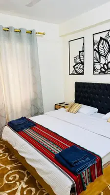 a bedroom with a bed with a blanket on it at New Hamoudeh Hotel in Amman