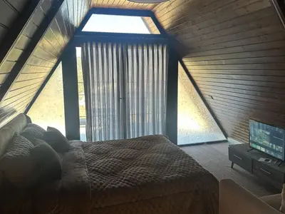 a bedroom with a bed and a large window at Umm Aljulud Cottages 01 in Ajloun